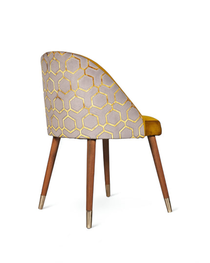 Modern mustard yellow velvet dining chair with wooden legs and gold metal tips, featuring patterned fabric back — ideal for contemporary interiors, dining rooms, or statement seating.