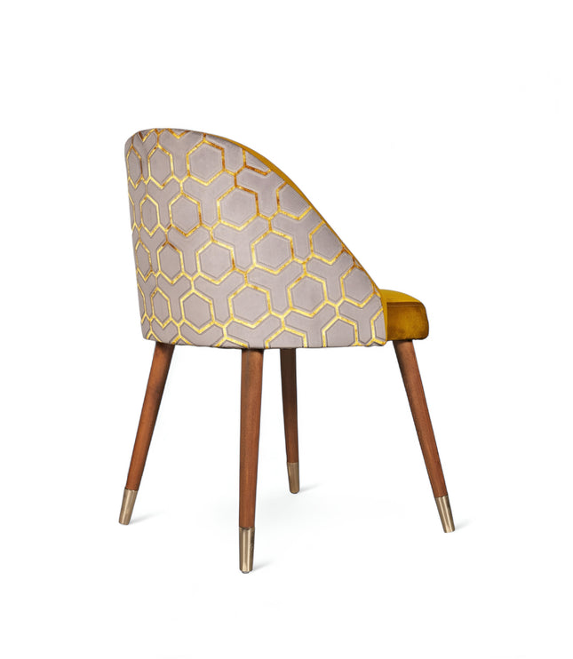 Modern mustard yellow velvet dining chair with wooden legs and gold metal tips, featuring patterned fabric back — ideal for contemporary interiors, dining rooms, or statement seating.