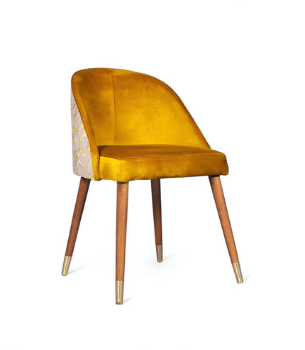 Modern mustard yellow velvet dining chair with wooden legs and gold metal tips, featuring patterned fabric back — ideal for contemporary interiors, dining rooms, or statement seating.
