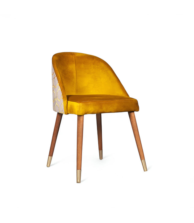 Modern mustard yellow velvet dining chair with wooden legs and gold metal tips, featuring patterned fabric back — ideal for contemporary interiors, dining rooms, or statement seating.