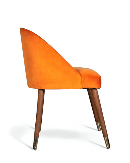 Modern orange velvet dining chair with wooden legs and golden tips— ideal for contemporary interiors, dining rooms, or statement seating.