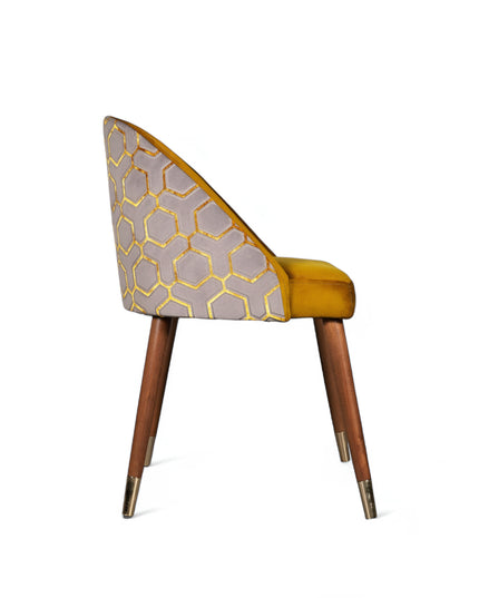 Modern mustard yellow velvet dining chair with wooden legs and gold metal tips, featuring patterned fabric back — ideal for contemporary interiors, dining rooms, or statement seating.