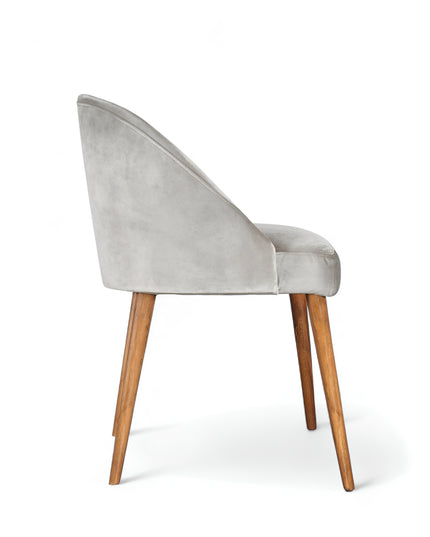 Modern silver velvet dining chair with wooden legs— ideal for contemporary interiors, dining rooms, or statement seating.