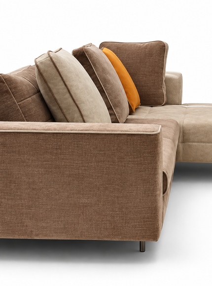 Amberley modern L-shaped sectional sofa with chaise lounge, neutral beige and taupe upholstery, amber accent cushion, included back cushions and slim metal legs.