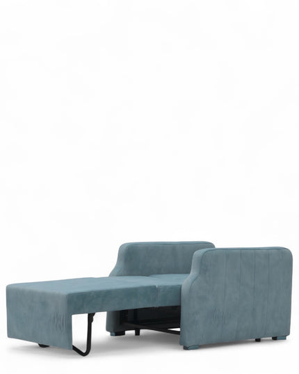 Contemporary blue lounge chair with a pull-out sleeper function and a soft pink accent pillow, featuring plush upholstery and modern lines—ideal for small spaces or guest rooms.