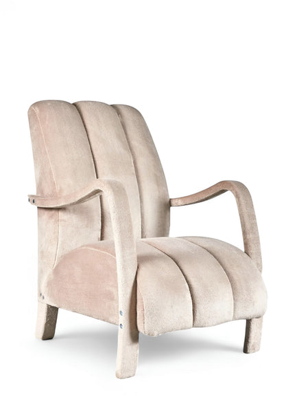 Aura Armchair in beige velvet-style upholstery with scalloped backrest, sculptural arms, and seamless upholstered legs; shown from front-angle, side, and rear perspectives.