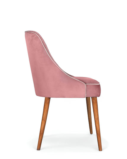 Contemporary side chair with pink curved backrest, studded trim, and wooden legs