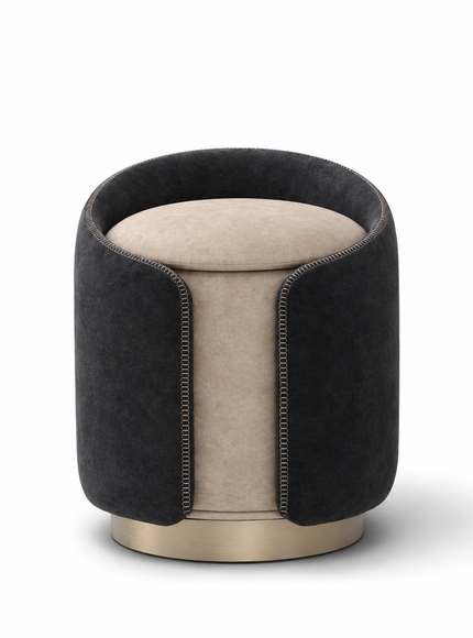 A modern cylindrical ottoman stool with a dark charcoal gray velvet outer sleeve, a light beige velvet seat cushion, and a brushed gold metal base, shown on a white background.