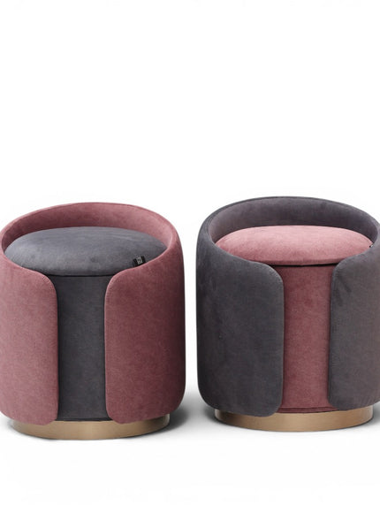 Two modern velvet ottomans with rounded cylindrical shapes in dusty pink and dark gray, featuring gold-toned wooden bases. 