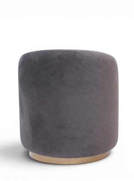 A cylindrical upholstered ottoman or stool in dusty grey velvet, featuring a light natural wood base, shown against a plain white background.