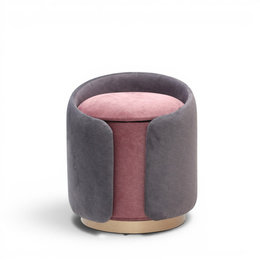 A cylindrical upholstered ottoman or stool in dusty grey velvet, featuring a light natural wood base, shown against a plain white background.