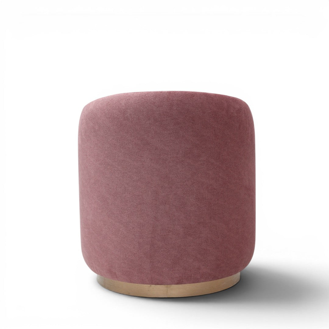 A cylindrical upholstered ottoman or stool in dusty rose pink velvet, featuring a light natural wood base, shown against a plain white background.