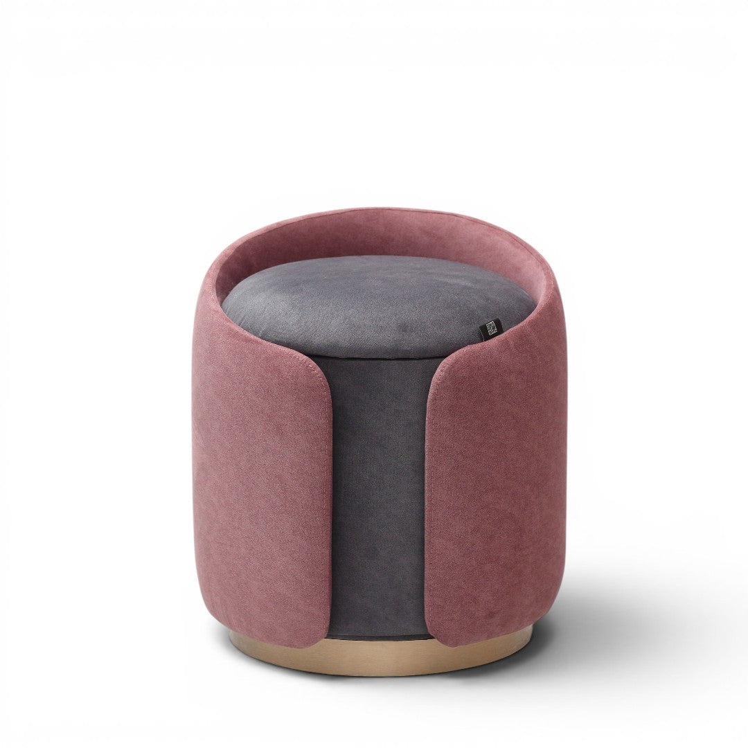 A cylindrical upholstered ottoman or stool in dusty rose pink velvet, featuring a light natural wood base, shown against a plain white background.