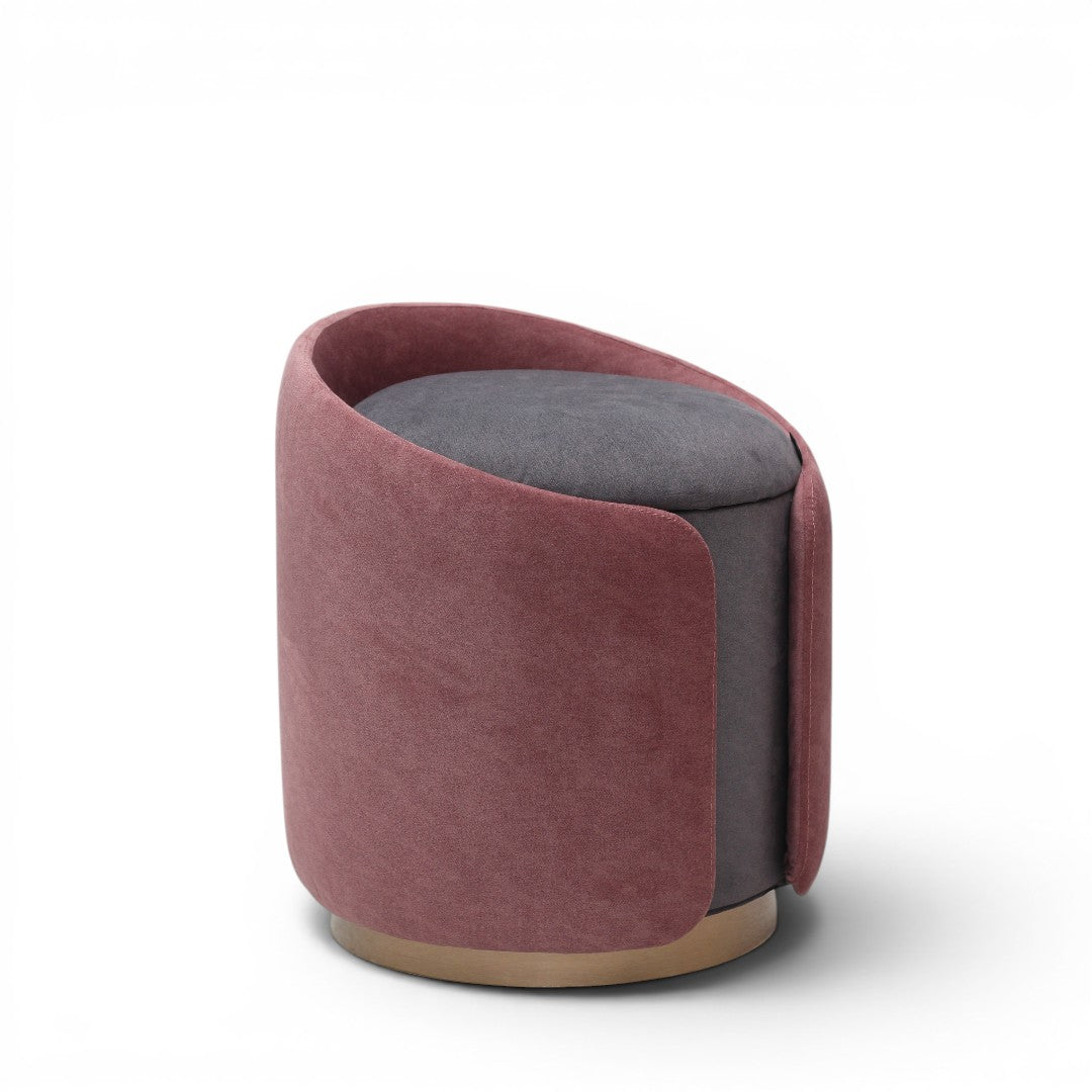 A cylindrical upholstered ottoman or stool in dusty rose pink velvet, featuring a light natural wood base, shown against a plain white background.