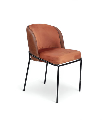 Modern terracotta velvet and leather accent chair with black metal legs — ideal for dining rooms, stylish interiors, or contemporary cafes seeking warmth and contrast.
