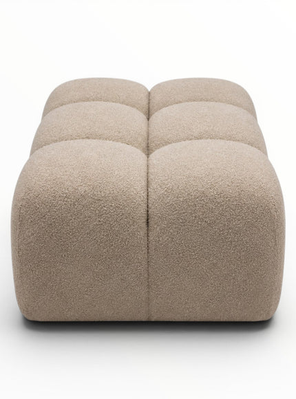 Beige cube-shaped ottoman on a white background