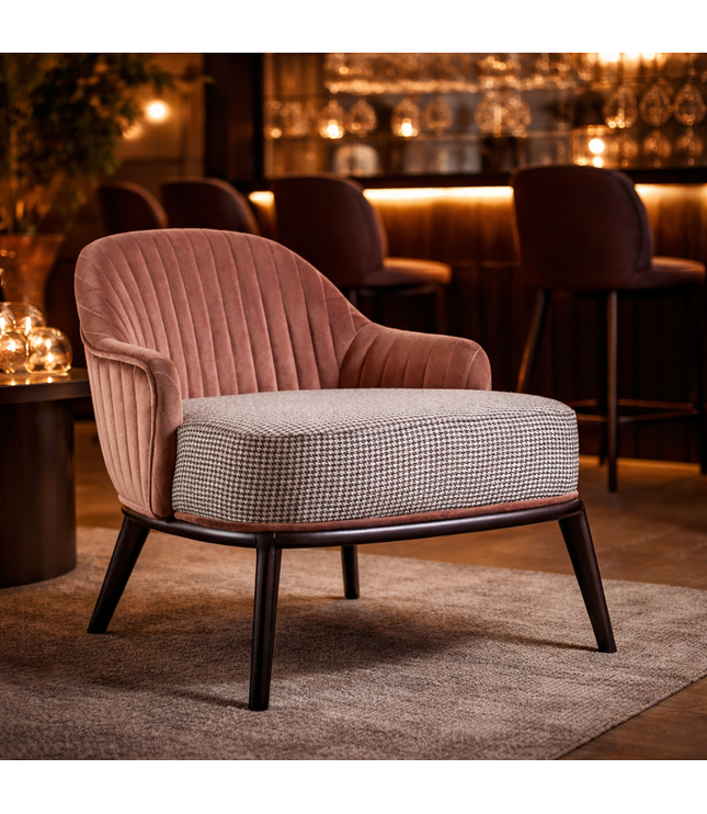 Pink armchair with a patterned seat in a warm-toned room.