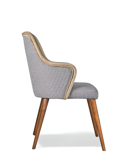 Houndstooth/beige upholstered armchair with high back, quilted sides, and wooden legs in a mid-century modern style