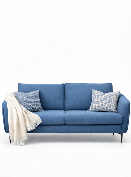 Blue sofa with decorative pillows and a blanket on a white background