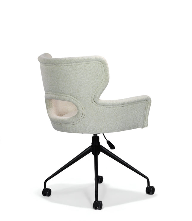 Wicky Swivel Chair in soft ivory boucle-style upholstery with sculptural cut-out backrest, flared arms, and black metal base on casters; shown in front three-quarter view.
