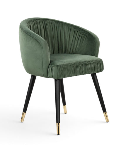 A green velvet barrel-style accent chair with black tapered legs and gold metal tips, shown against a plain white background.