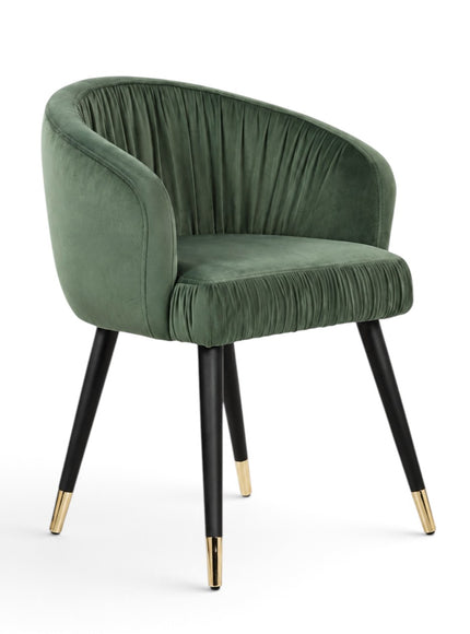 A green velvet barrel-style accent chair with black tapered legs and gold metal tips, shown against a plain white background.