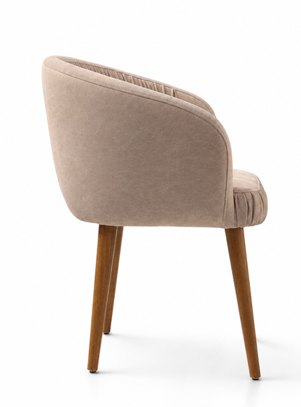 A modern barrel-style accent chair upholstered in a textured beige velvet fabric with a curved backrest and pleated detailing, supported by four tapered medium-brown wooden legs, shown on a clean white background.