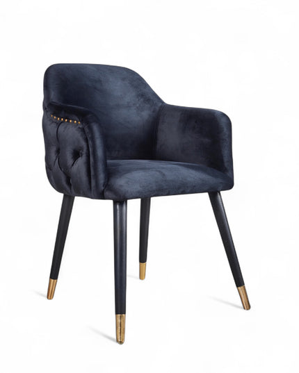 Dark blue velvet accent chair with tufted arm detailing and tapered wooden legs — ideal for modern dining rooms, vanity seating, or boutique interiors.