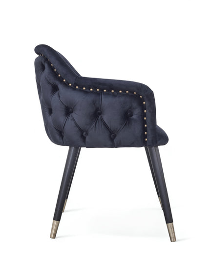 Dark blue velvet accent chair with tufted arm detailing and tapered wooden legs — ideal for modern dining rooms, vanity seating, or boutique interiors.
