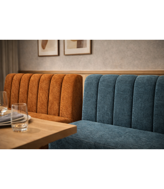Two upholstered benches, one orange and one blue, in a room with a table and glasses.