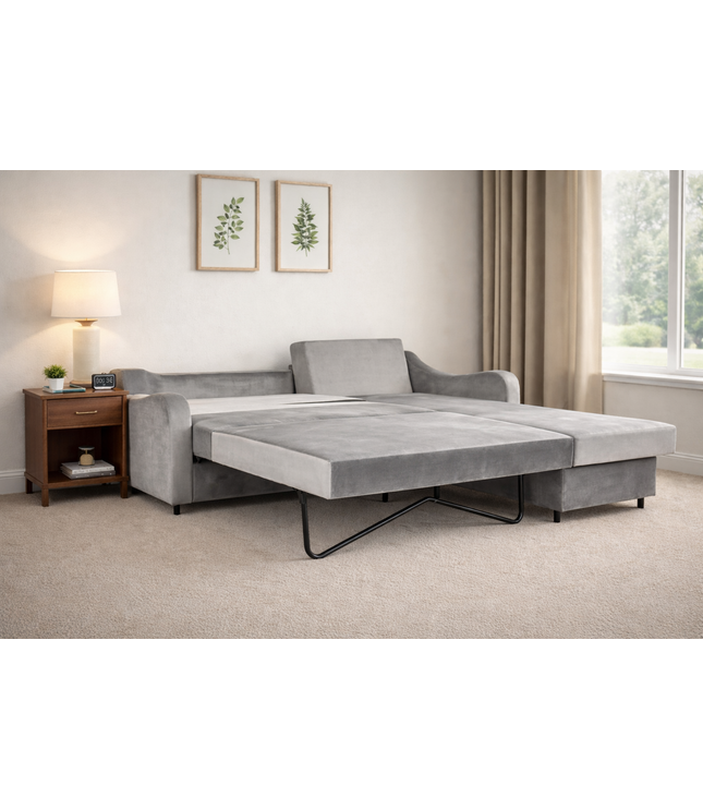 Gray sofa bed in a living room setting with a side table and lamp.