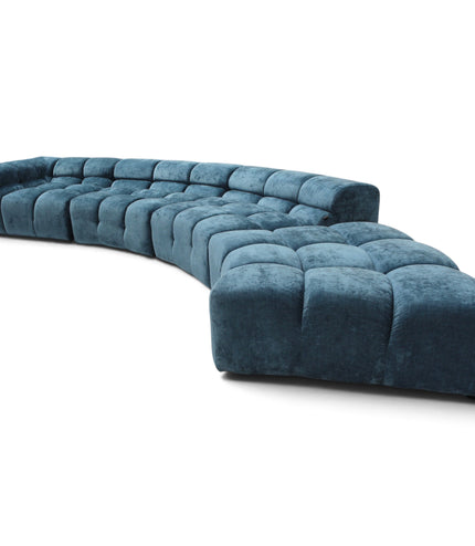 A curved modular sectional sofa upholstered in deep teal velvet, featuring tufted square cushions, shown on a plain white background.