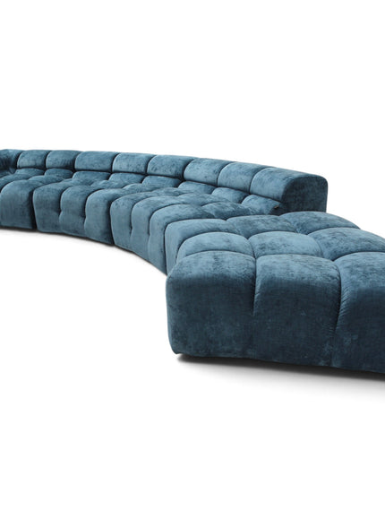 A curved modular sectional sofa upholstered in deep teal velvet, featuring tufted square cushions, shown on a plain white background.