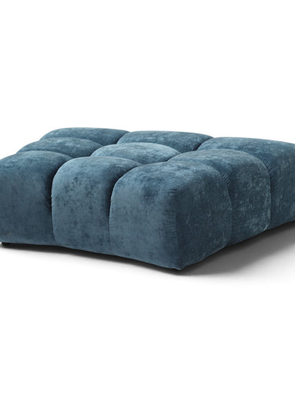 A modern tufted ottoman in a textured blue velvet fabric, shown from a three-quarter angle on a clean white background.