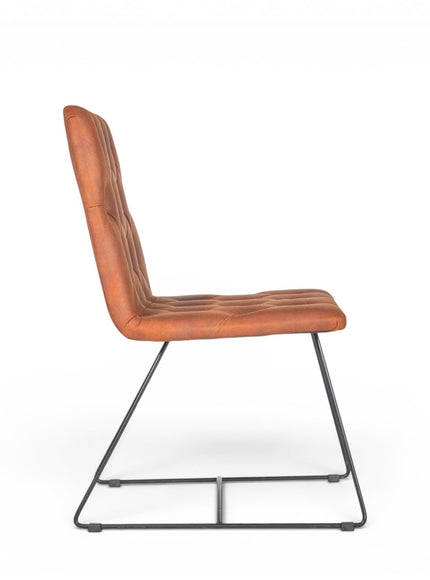 Side view of the Vaya Home Hudson dining chair showing the button-tufted brown faux leather seat, tall backrest, and black metal sled legs.