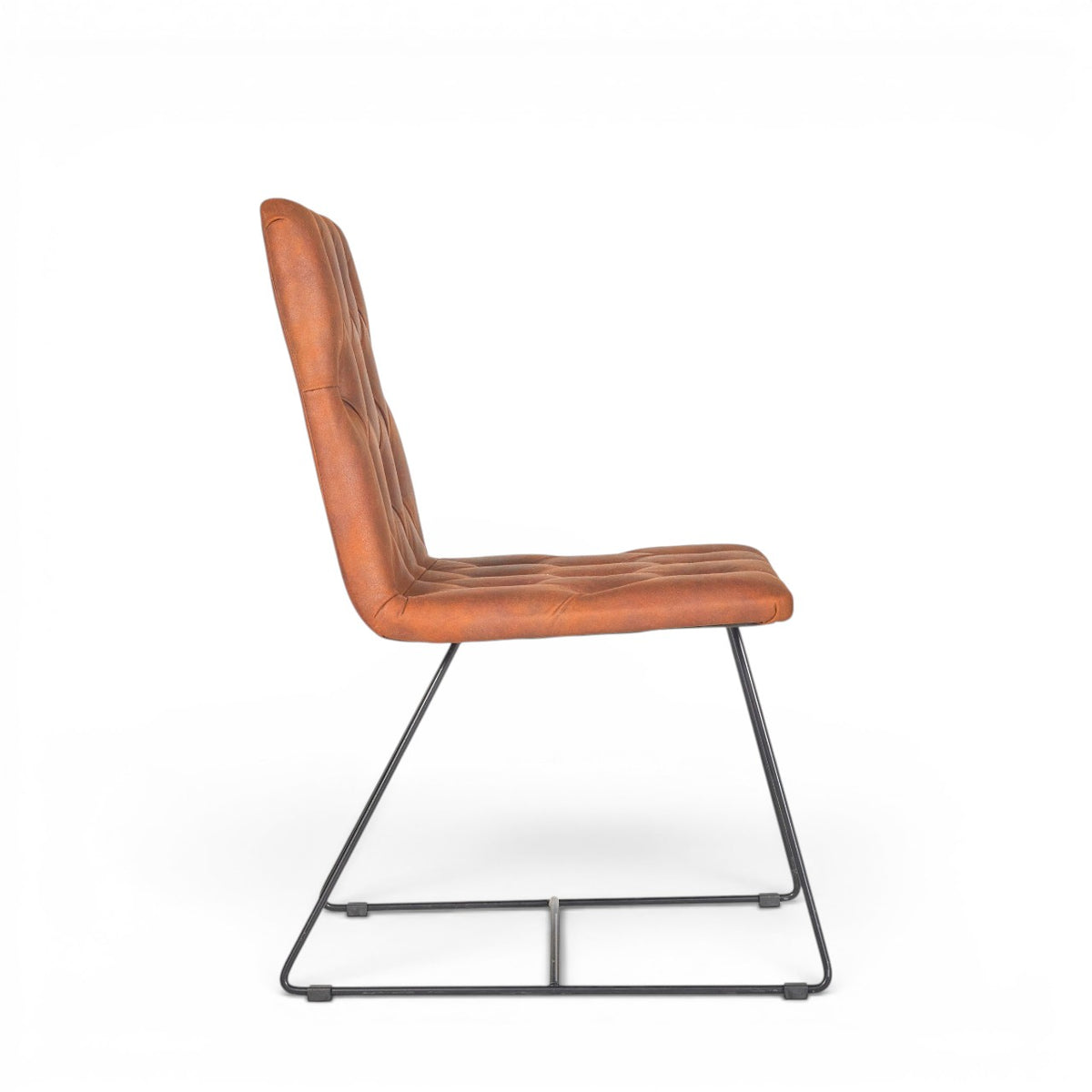 Side view of the Vaya Home Hudson dining chair showing the button-tufted brown faux leather seat, tall backrest, and black metal sled legs.