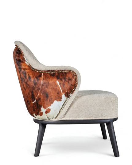 Kalv Armchair with beige fabric front, cowhide-style back panel, brass nailhead trim, and black tapered legs; shown from side, angled front, and rear views.

