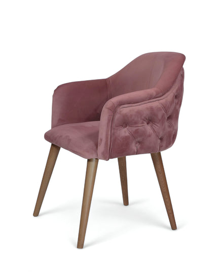 Blush pink velvet accent chair with tufted arm detailing and tapered wooden legs — ideal for modern dining rooms, vanity seating, or boutique interiors.