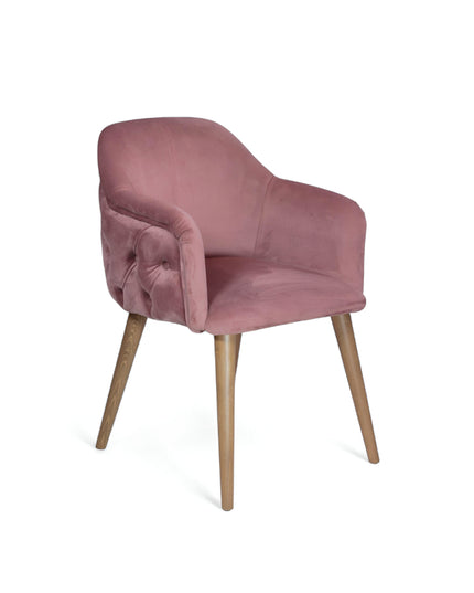 Blush pink velvet accent chair with tufted arm detailing and tapered wooden legs — ideal for modern dining rooms, vanity seating, or boutique interiors.