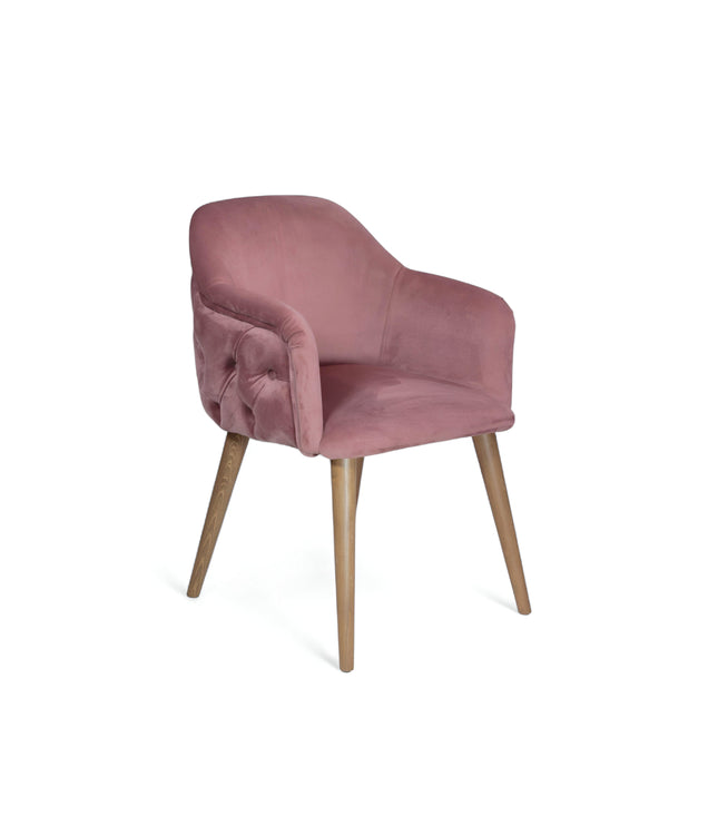 Blush pink velvet accent chair with tufted arm detailing and tapered wooden legs — ideal for modern dining rooms, vanity seating, or boutique interiors.