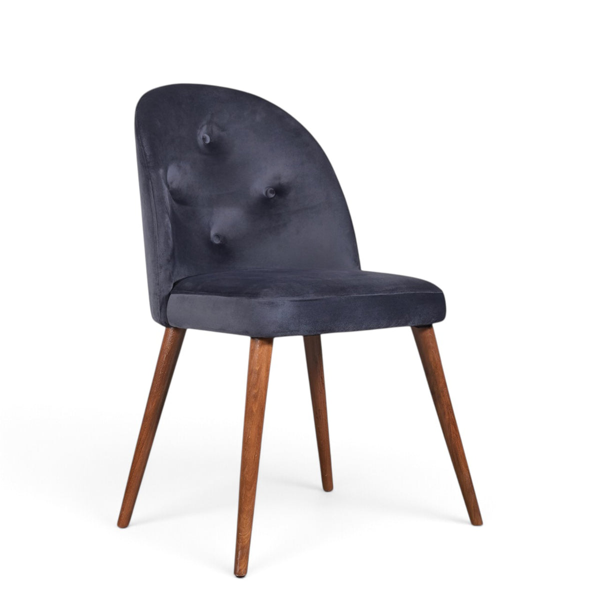 A modern dining chair with a dark navy blue velvet upholstered seat and curved backrest featuring button tufting, supported by four tapered medium-brown wooden legs, shown on a plain white background.