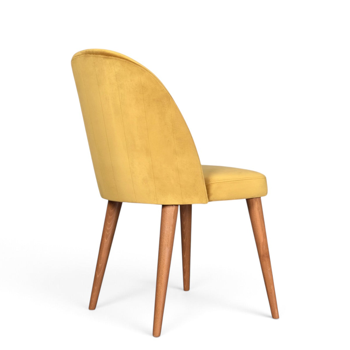 A modern dining chair with a curved back upholstered in mustard yellow velvet, supported by four tapered medium-brown wooden legs, shown from a three-quarter angle on a white background.