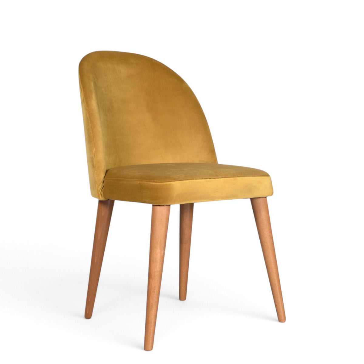 A modern dining chair with a curved back upholstered in mustard yellow velvet, supported by four tapered medium-brown wooden legs on a white background.
