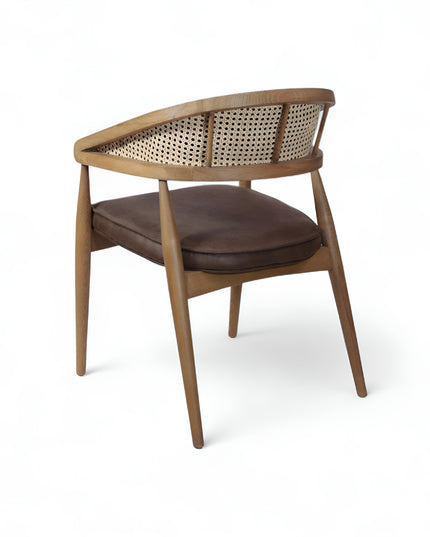 Mid-century modern accent chair with curved oak frame, woven cane side panels, and dark brown faux leather upholstery, ideal for dining rooms or stylish home offices.