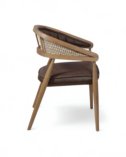 Mid-century modern accent chair with curved oak frame, woven cane side panels, and dark brown faux leather upholstery, ideal for dining rooms or stylish home offices.
