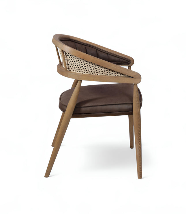 Mid-century modern accent chair with curved oak frame, woven cane side panels, and dark brown faux leather upholstery, ideal for dining rooms or stylish home offices.
