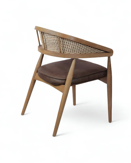 Mid-century modern accent chair with curved oak frame, woven cane side panels, and dark brown faux leather upholstery, ideal for dining rooms or stylish home offices.