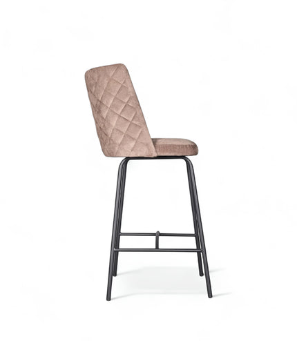 Modern bar stool with beige upholstery, quilted side detailing, and slender black metal legs with a footrest, ideal for kitchen islands or contemporary home bars