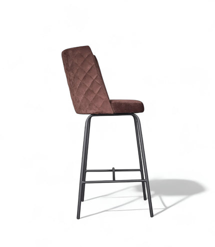 Modern bar stool with brown upholstery, quilted side detailing, and slender black metal legs with a footrest, ideal for kitchen islands or contemporary home bars