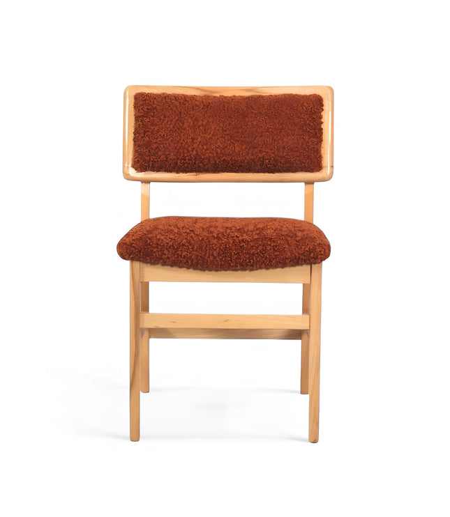 Rustic accent chair with burnt orange shearling-style upholstery and natural wood frame, ideal for modern farmhouse or boho interiors.